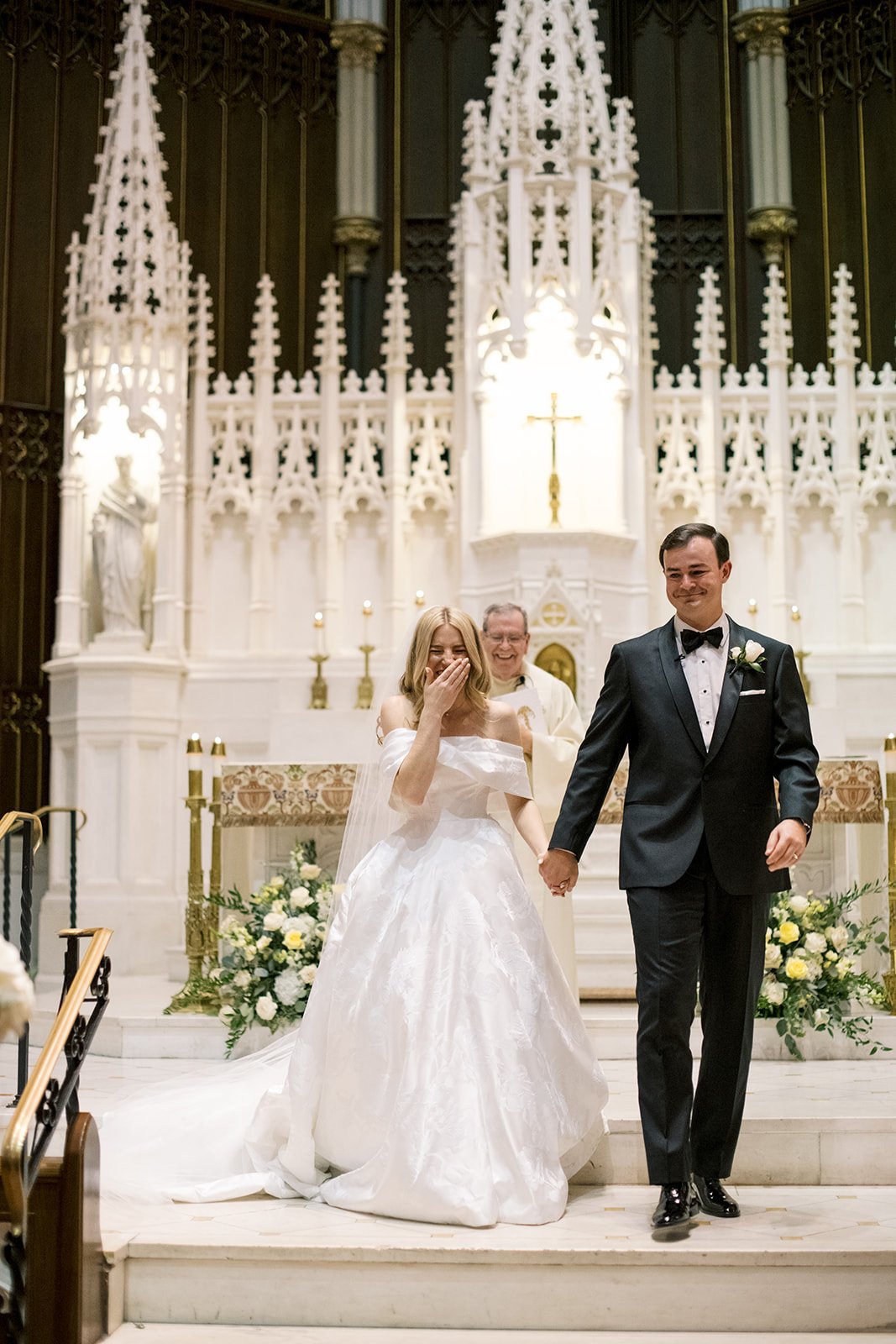 Bride and groom standing at church altar with big smiles