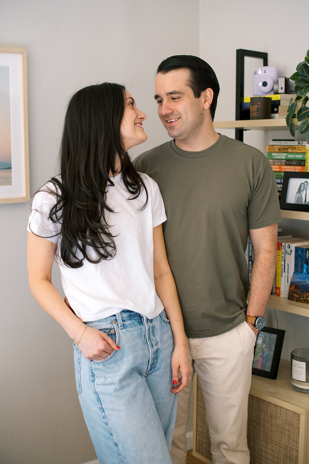  couple standing close together looking at one another and smiling 