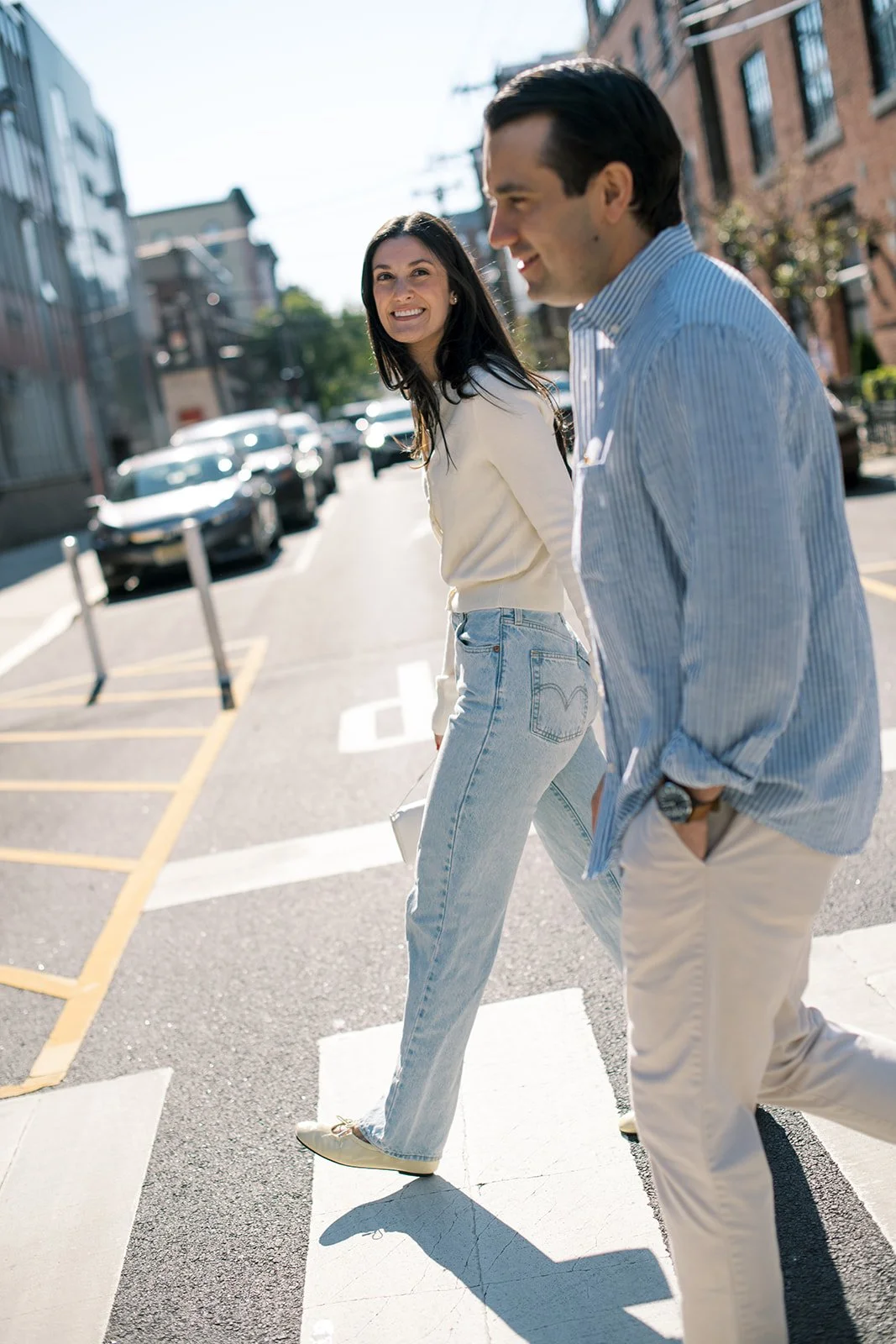  couple crossing the street in Hoboken with the girl looking across at her fiance 
