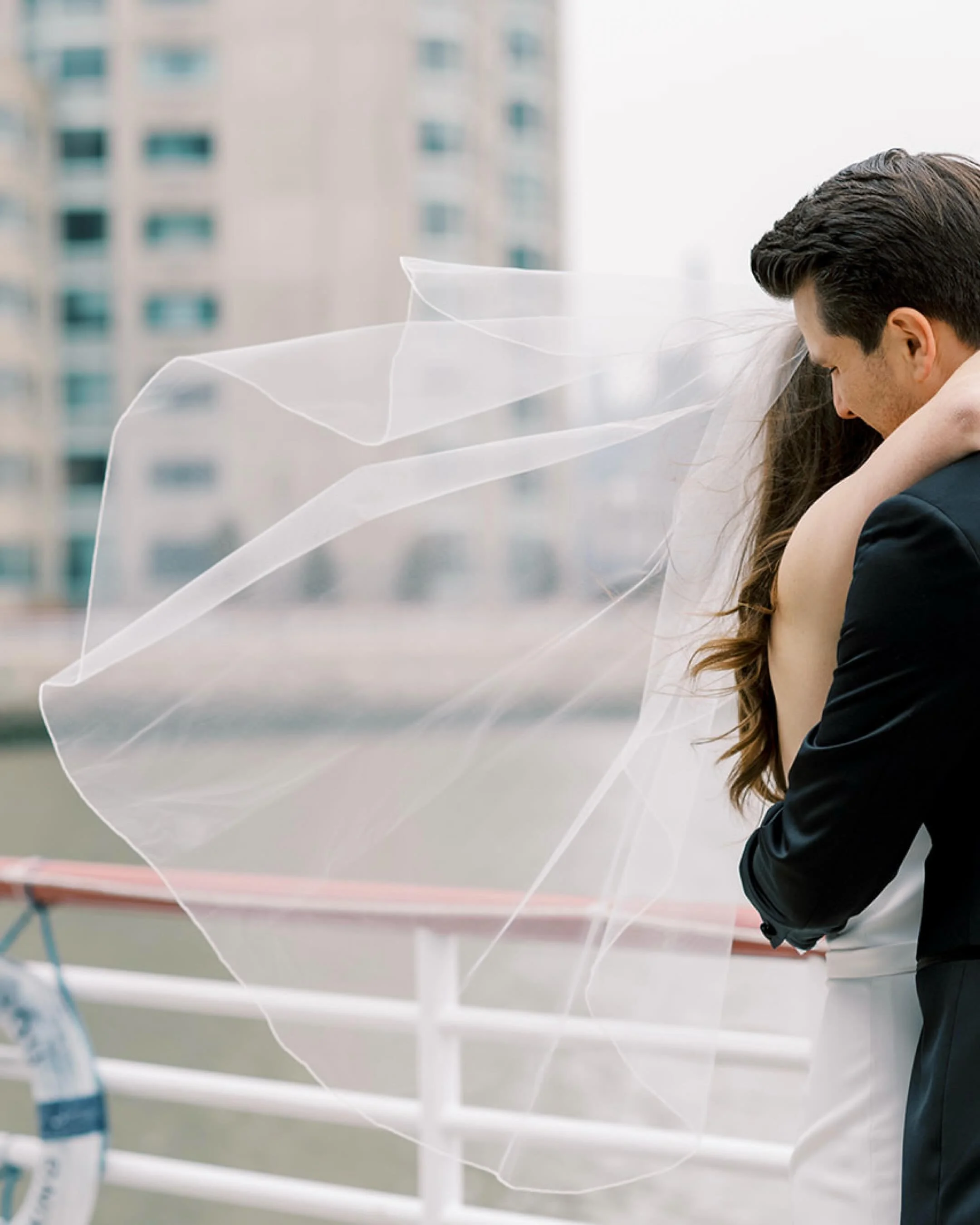 The wind was blowing as we took pictures by the water, but Brian was always available for an embrace. Lauren wore a short veil which is just perfect for a city wedding! She looked stunning in her @justinalexander gown. @laurenzychowski @bwzych 
.
.
G