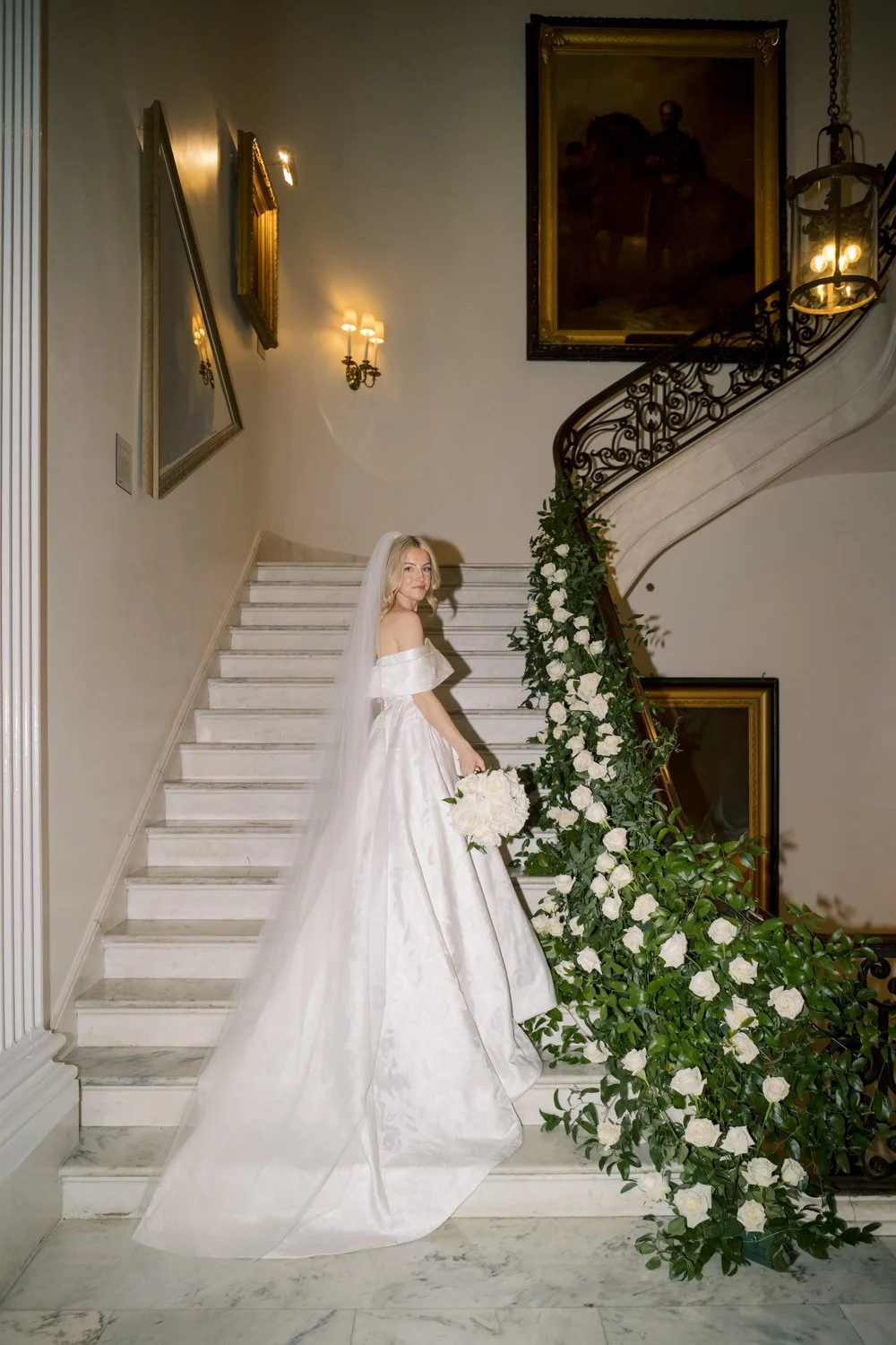direct flash bridal portrait on marble staircase with cascading white flowers and greenery