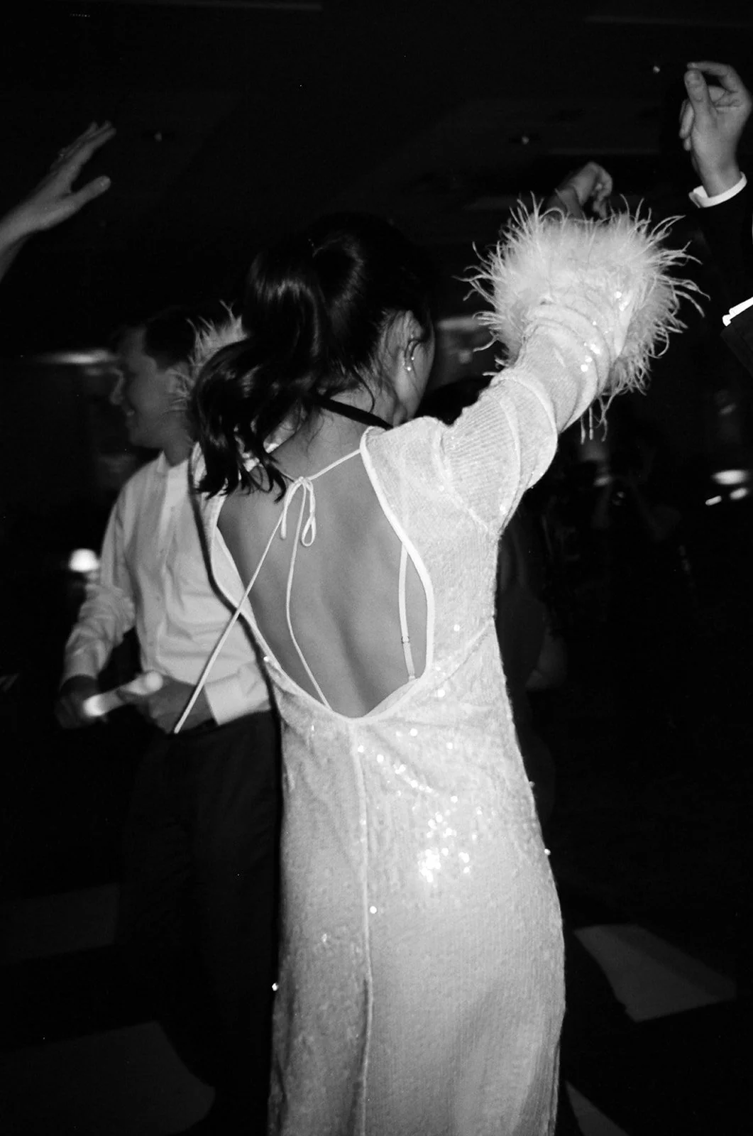 Back of bride's sequin dress with feather cuffs