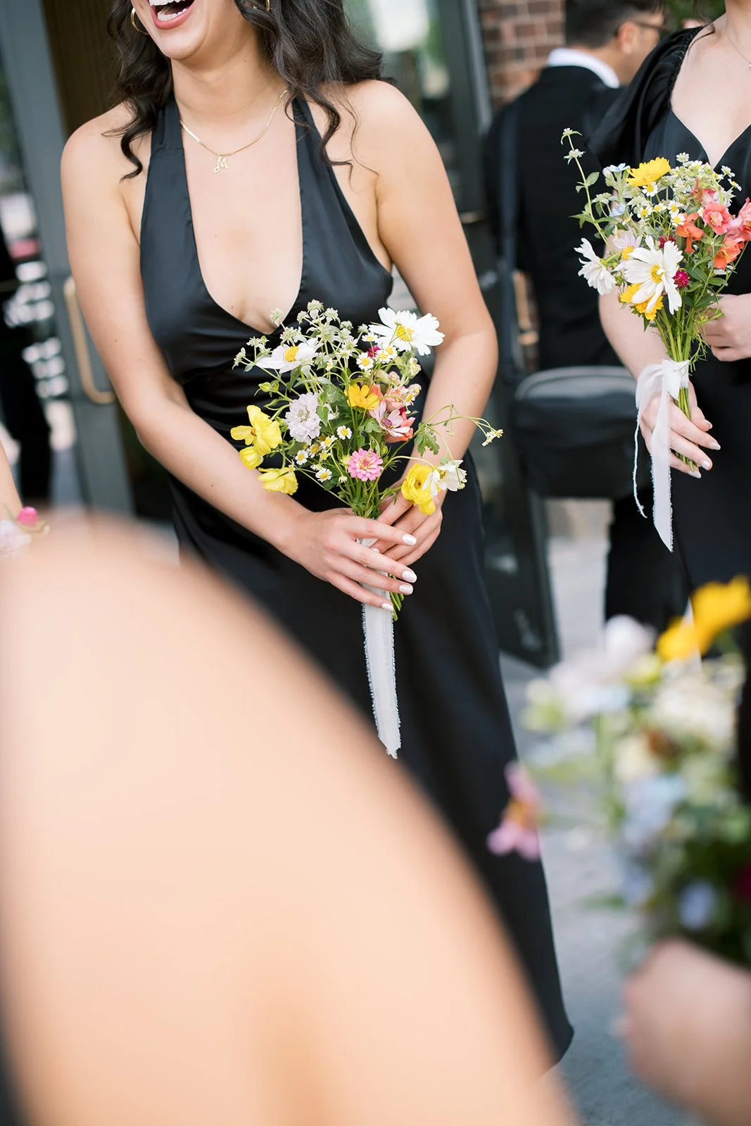 wildflower bouquet held against a black dress. Battello wedding