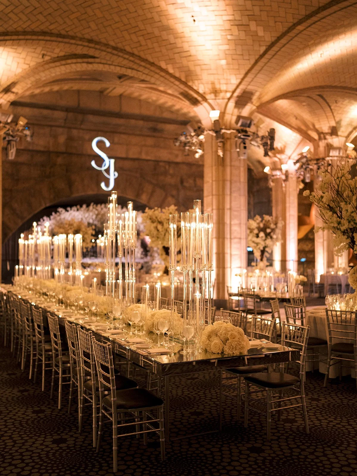 Guastavinos reception room decorated with long tables with large candelabras and white flowers 