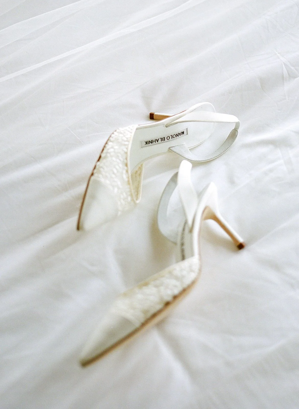 White lace high-heeled shoes on a white surface