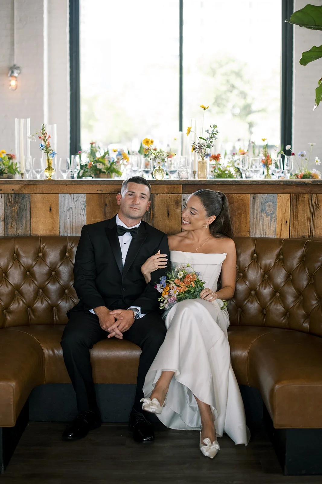 black tie couple sitting in leather booth at Battello