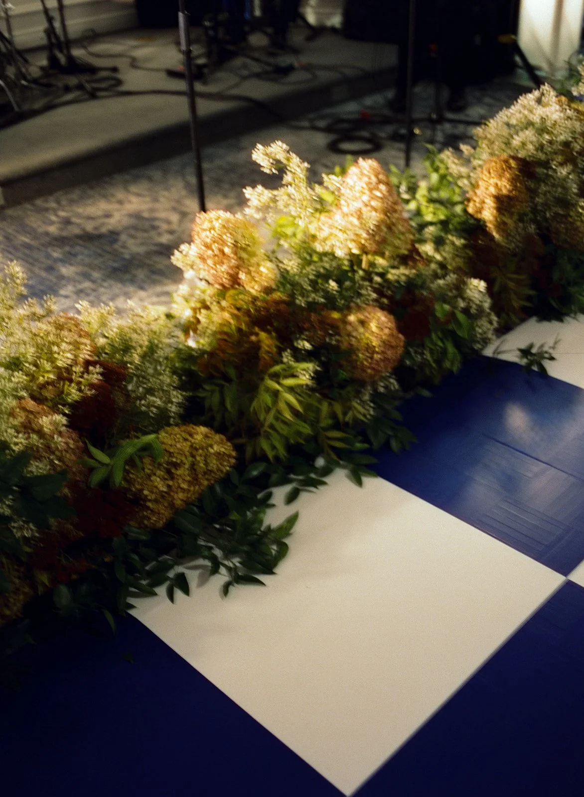 large floral bouquets line a checkered dance floor