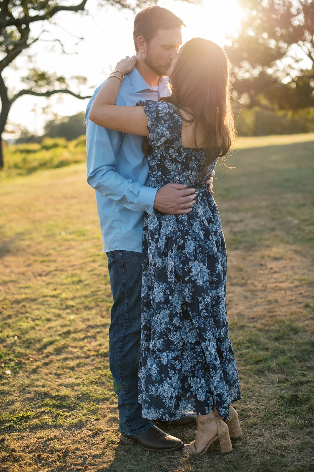 Hetero couple kissing with the sunset behind them