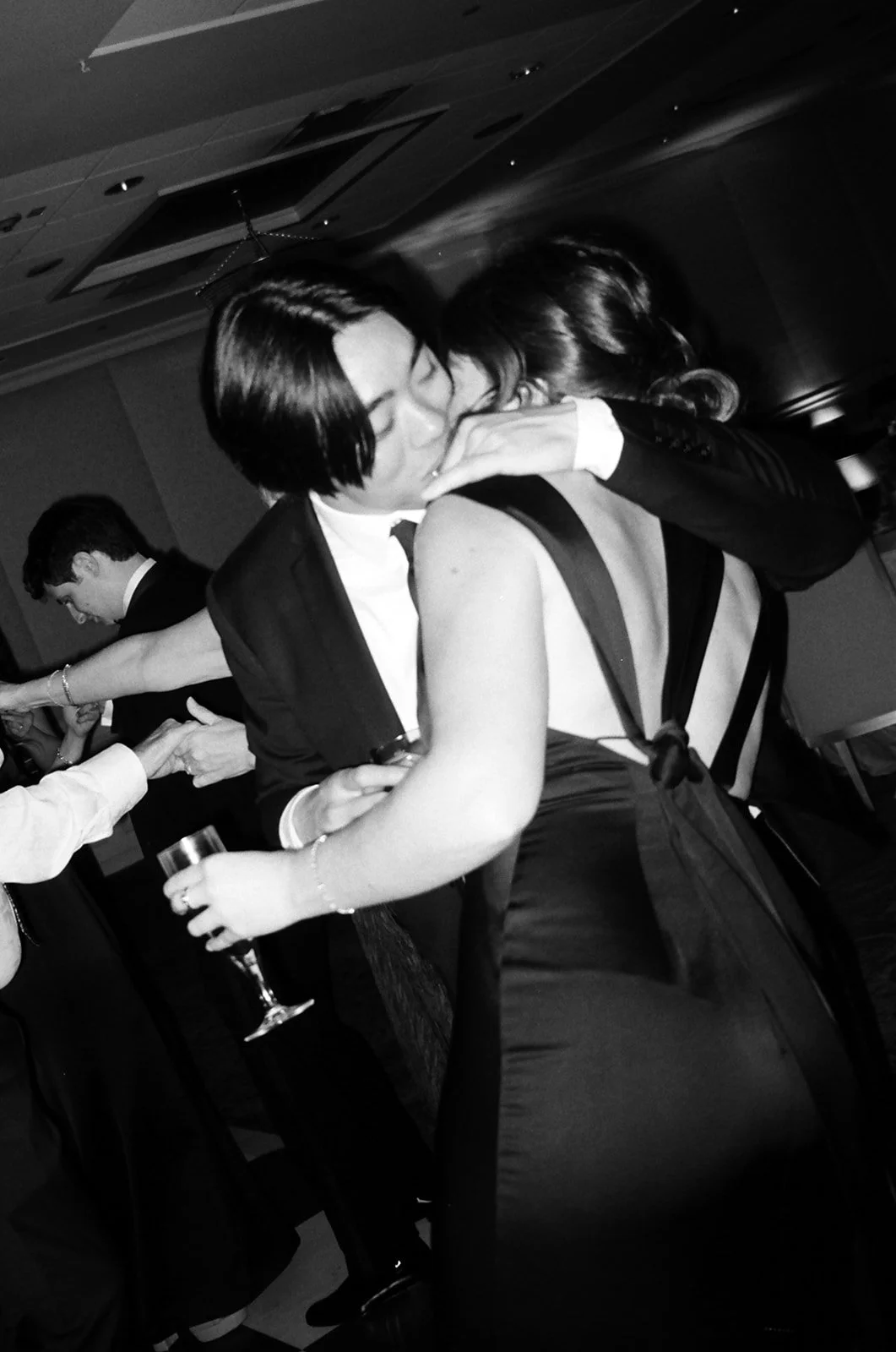 Couple kissing on the dance floor holding flutes of champagne