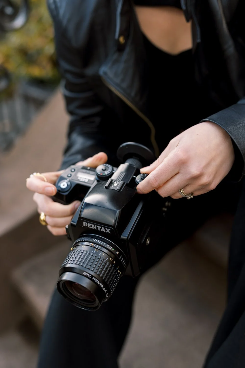 Close up of photographer's hands holding a Pentax film camera