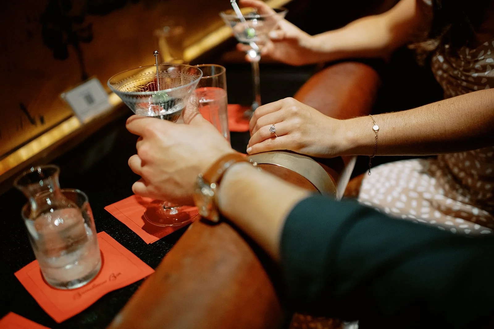 Close up of hands holding martinis at Bemelman's Bar in NYC