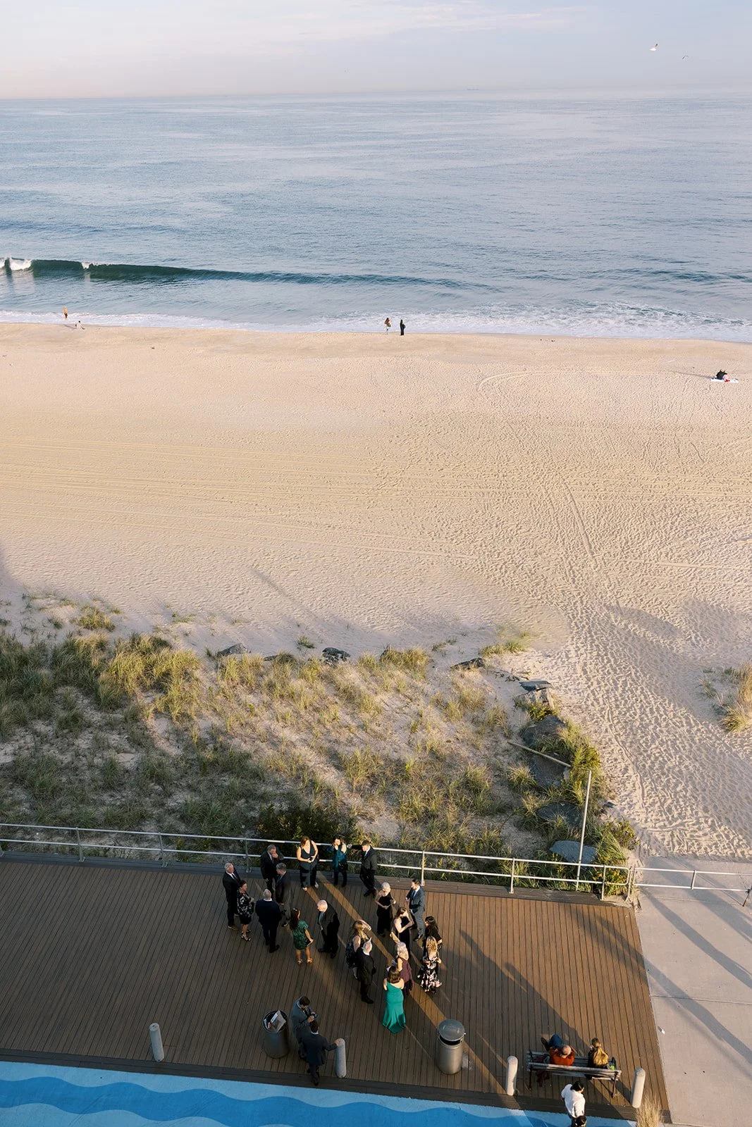 overhead photo of wedding guests on the boardwalk during sunset at Wave Resort