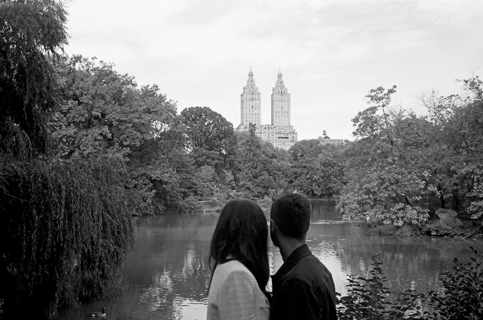 Backs of couple as they look over a lake in Central Park, NYC. Black and white image
