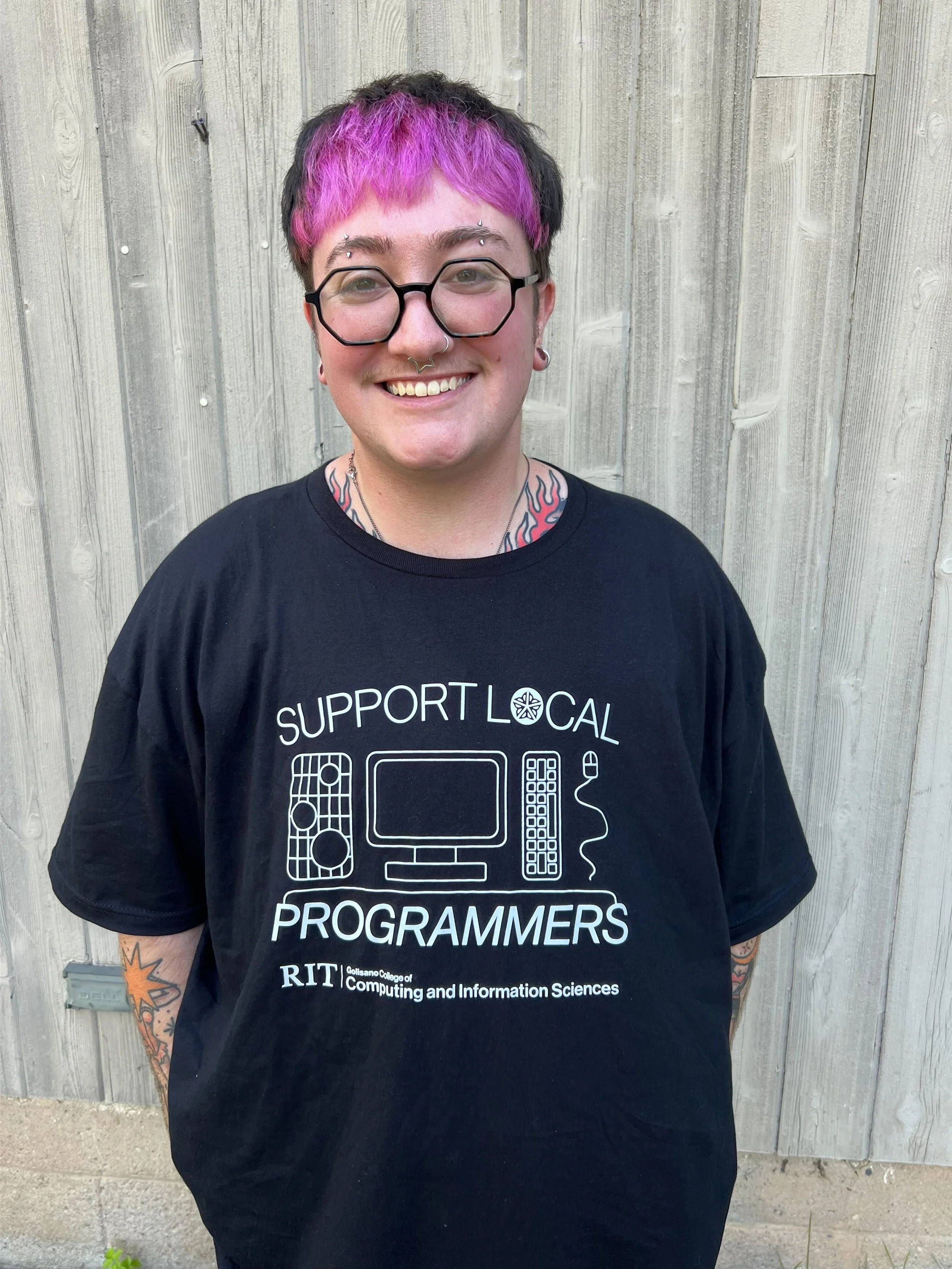 micah wearing a tshirt that reads "support local programmers" for the RIT College of Computing