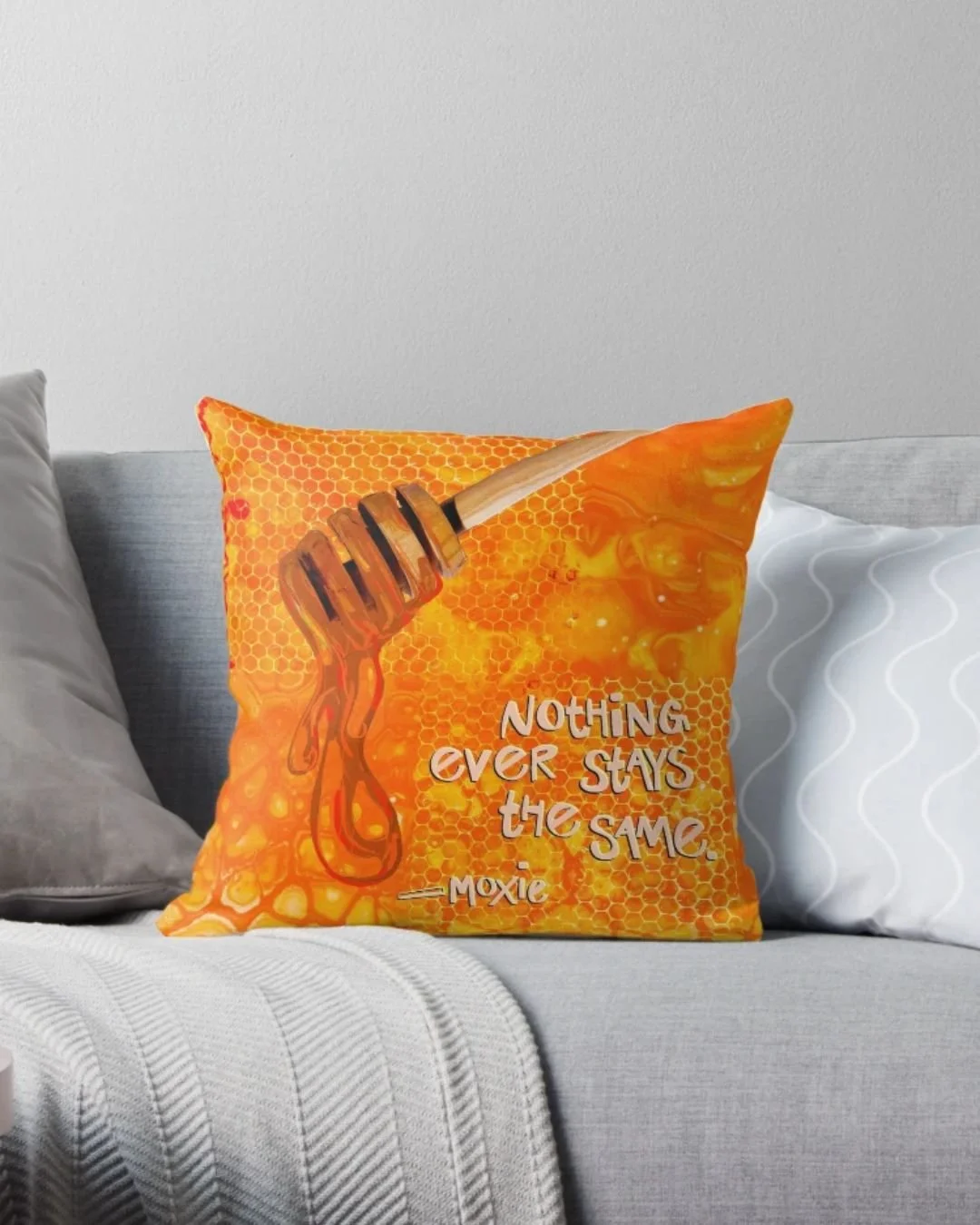 pillow with honey motifs reads "nothing ever stays the same - moxie"