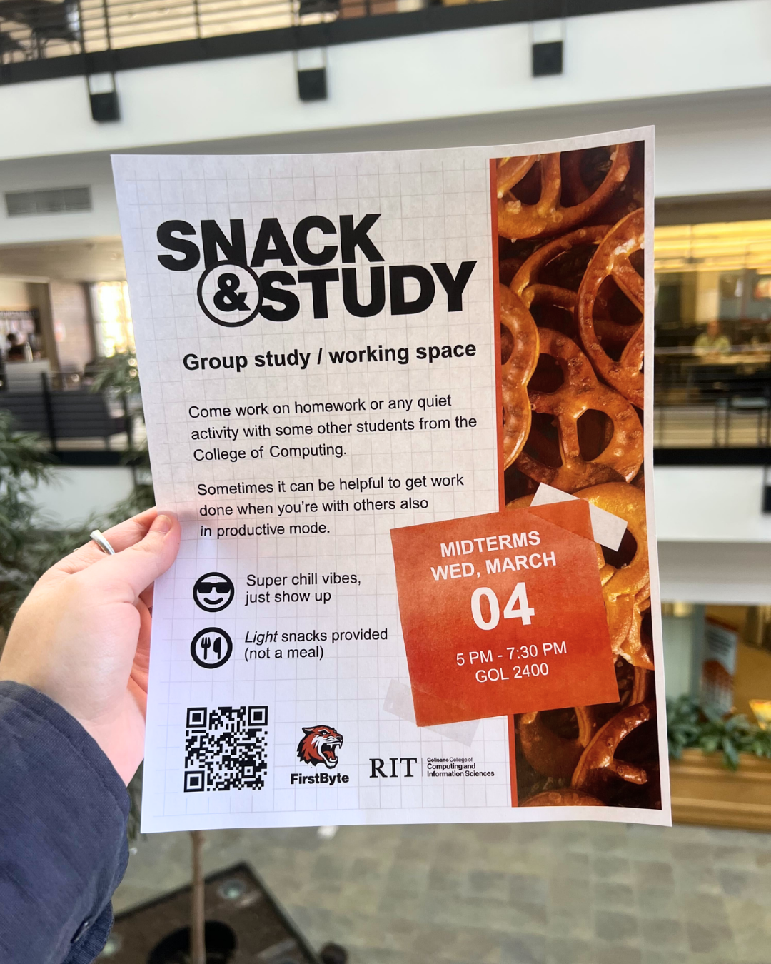 Hand holding a flyer for Snack & Study event