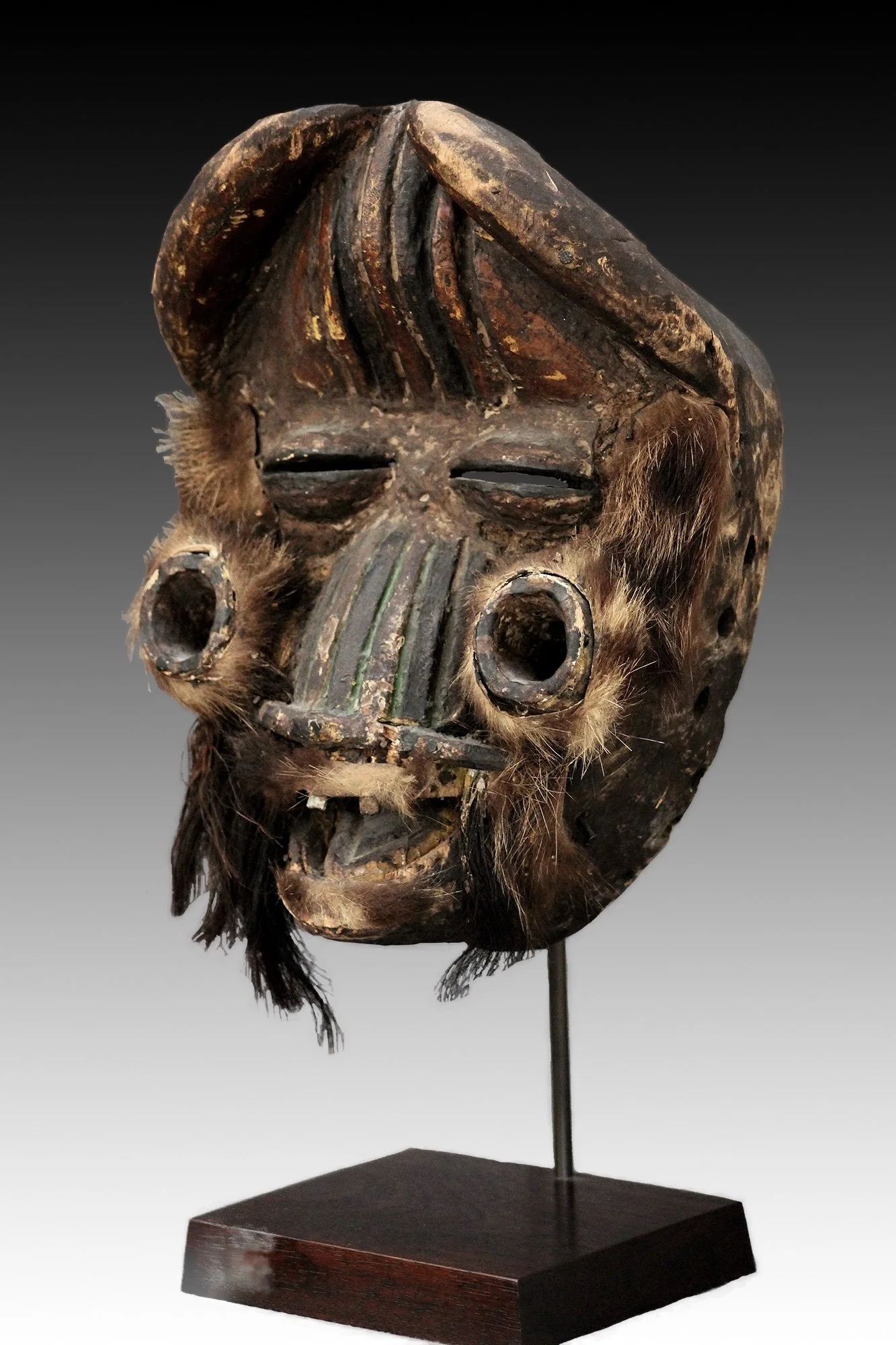 Classic We mask with metal teeth, broad nose, bulging forehead, coffee-bean eyes and two cylindrical projections from the cheeks.  www.gallerytribalart.com