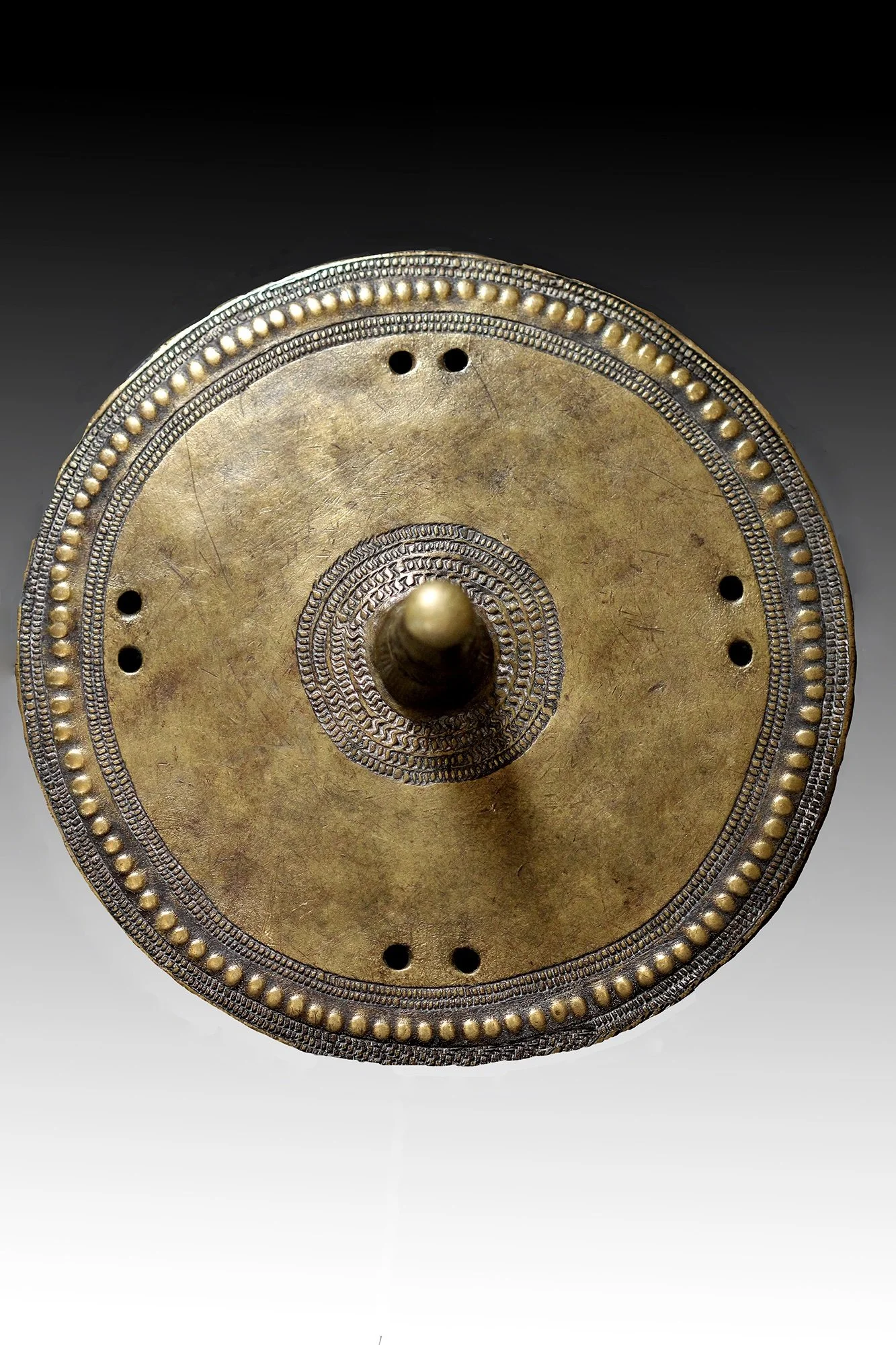 Borana brass ornament is disc shaped like an Ethiopian shield with a large projection in the middle.  www.gallerytribalart.com