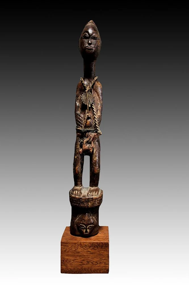 Baule figure wearing a old brass medallion with concentric circles.  www.gallerytribalart.com