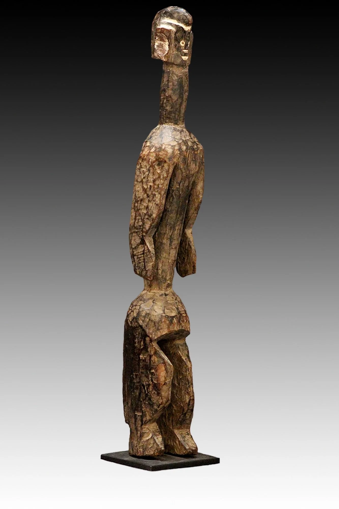 Mumuye figure stands on wedge shaped feet with tapered hips supporting a cylindrical bust with open work arms.  www.gallerytribalart.com