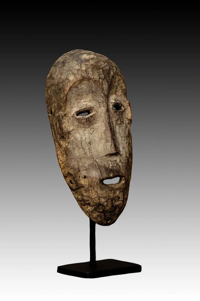 Lega mask has pierced oval eyes and linear nose.  www.gallerytribalart.com