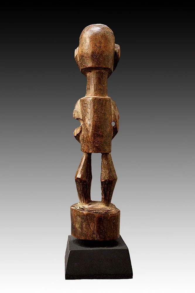 Songye figure has bent legs standing on a curcular pedestal.  www.gallerytribalart.com