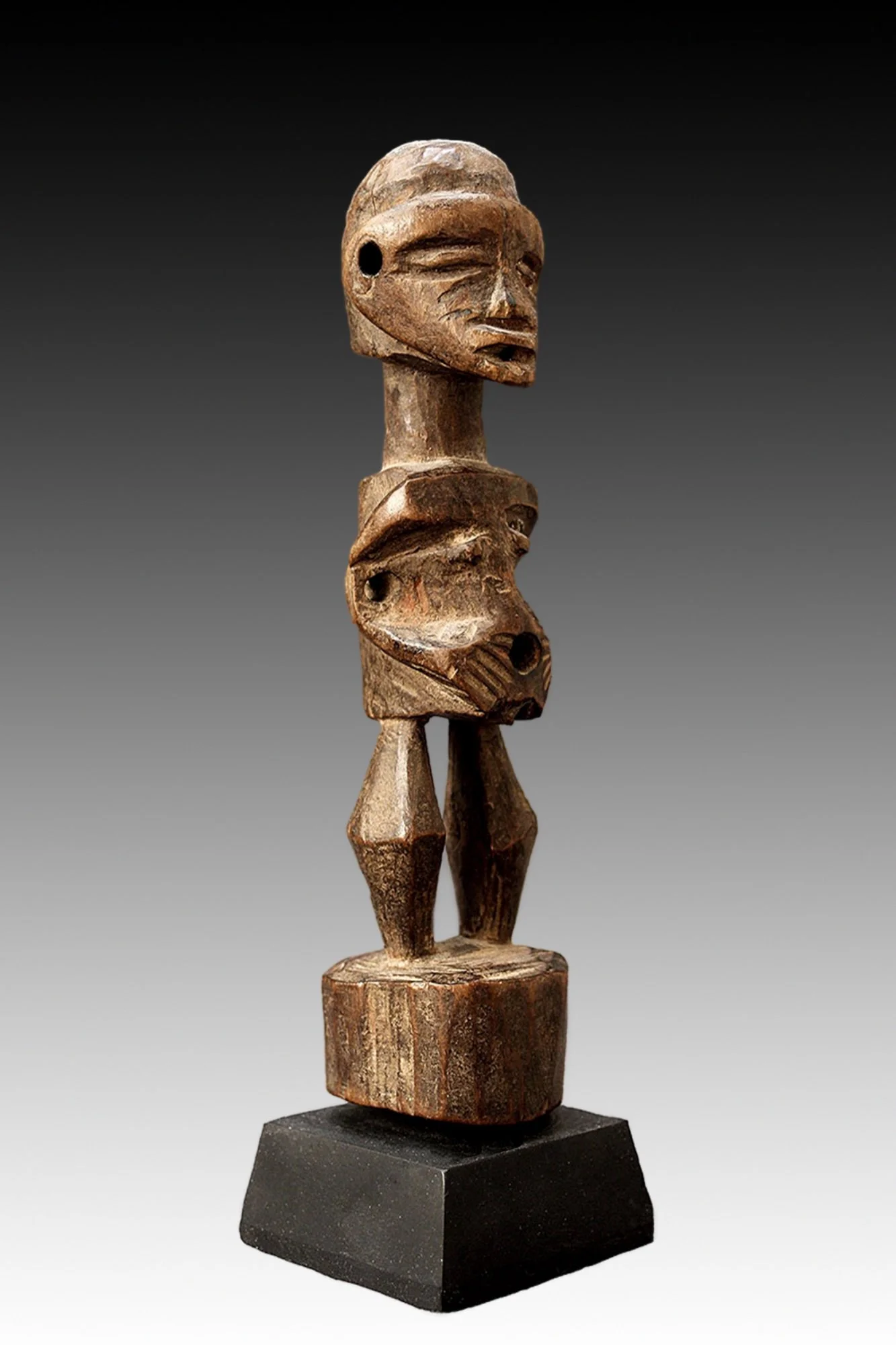 Songye fetish figure, the face is stylized and there are holes on top of the head, abdomen, ears and arms from use.  www.gallerytribalart.com