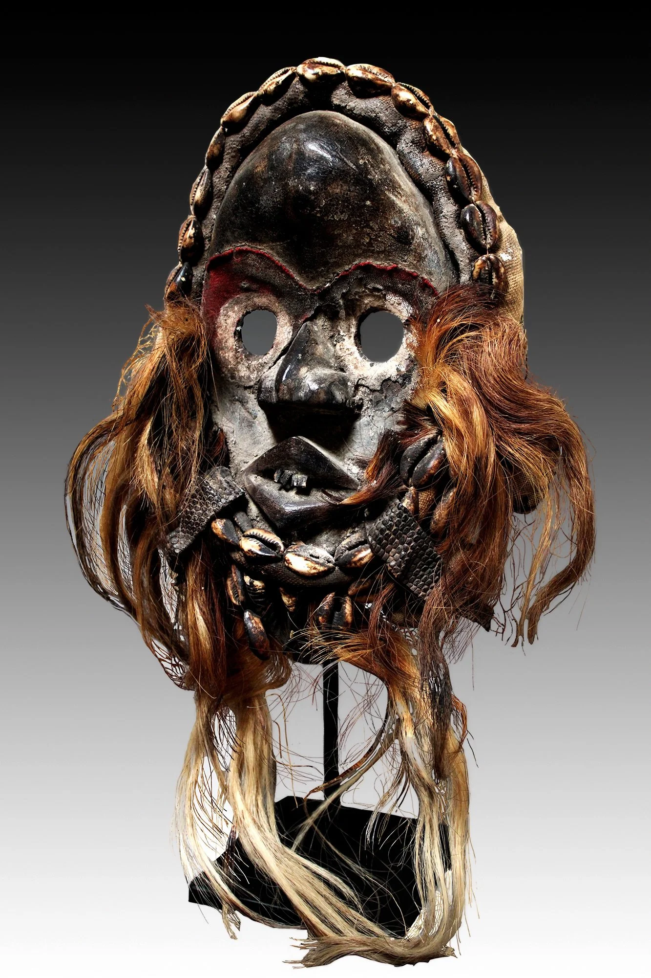 The Dan Zakpai mask  is decorated with burlap bundles, cowrie shells, animal hair, reptile skin, metal teeth and remnants of red fiber.  www.gallerytribalart.com