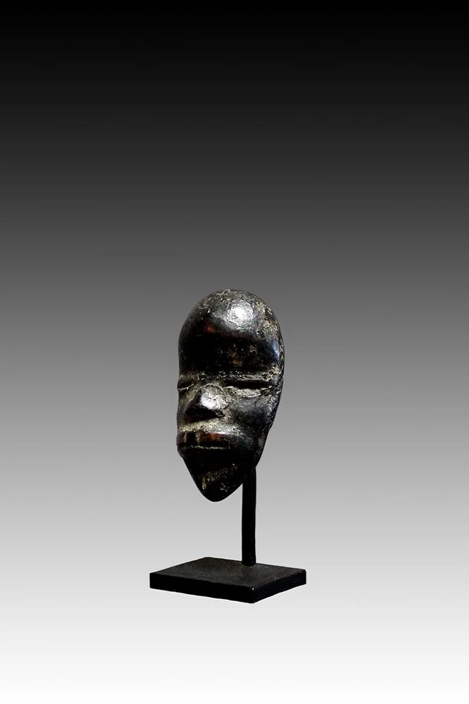 Dan mask with slit eyes, small nose and mouth baring teeth.  www.gallerytribalart.com