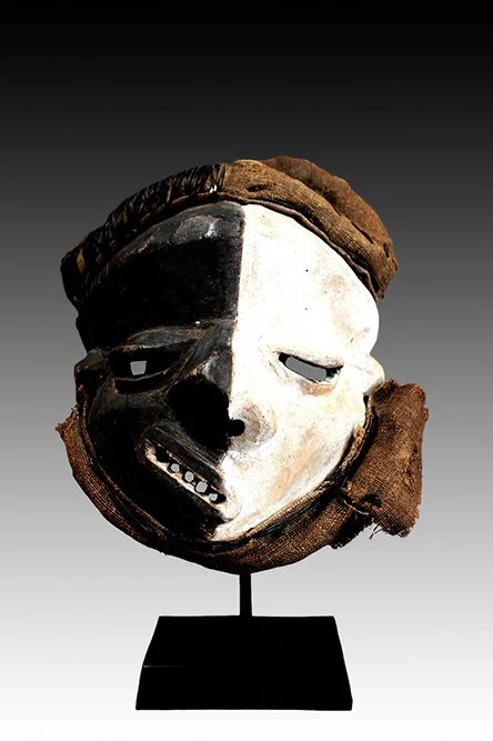 Pende sickness mask is divided black and white.  www.gallerytribalart.com