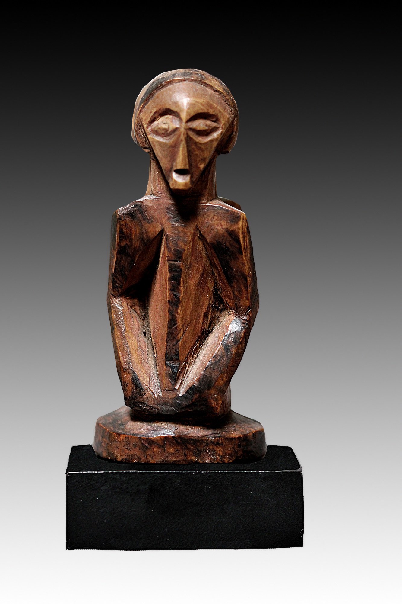 Bembe miniature figure has an elegant cubistic, triangular face with long bent arms resting on the abdomen.  www.gallerytribalart.com