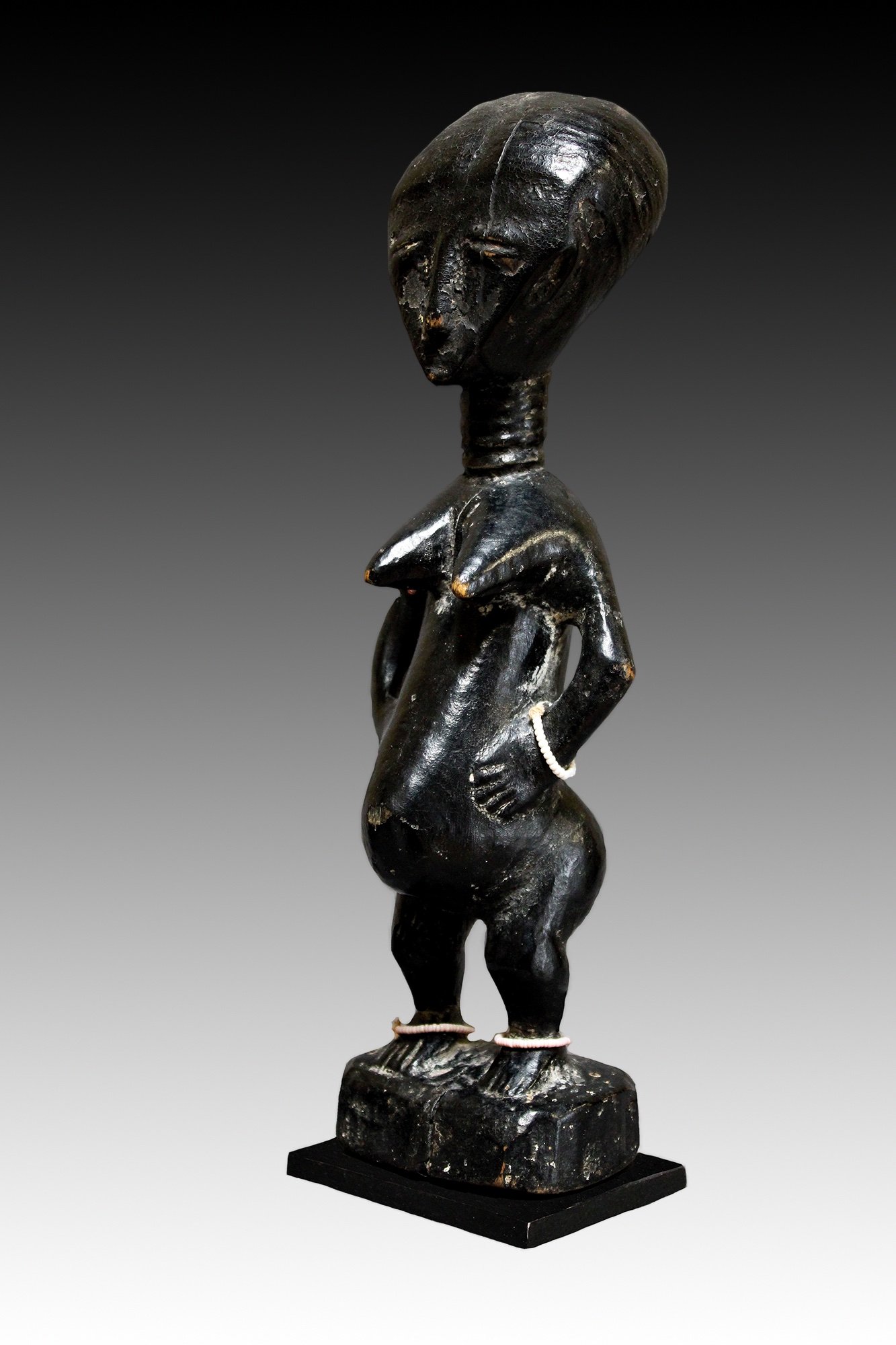 Akan figure has a glossy black patina with a domed head, ringed neck and beads.  www.gallerytribalart.com