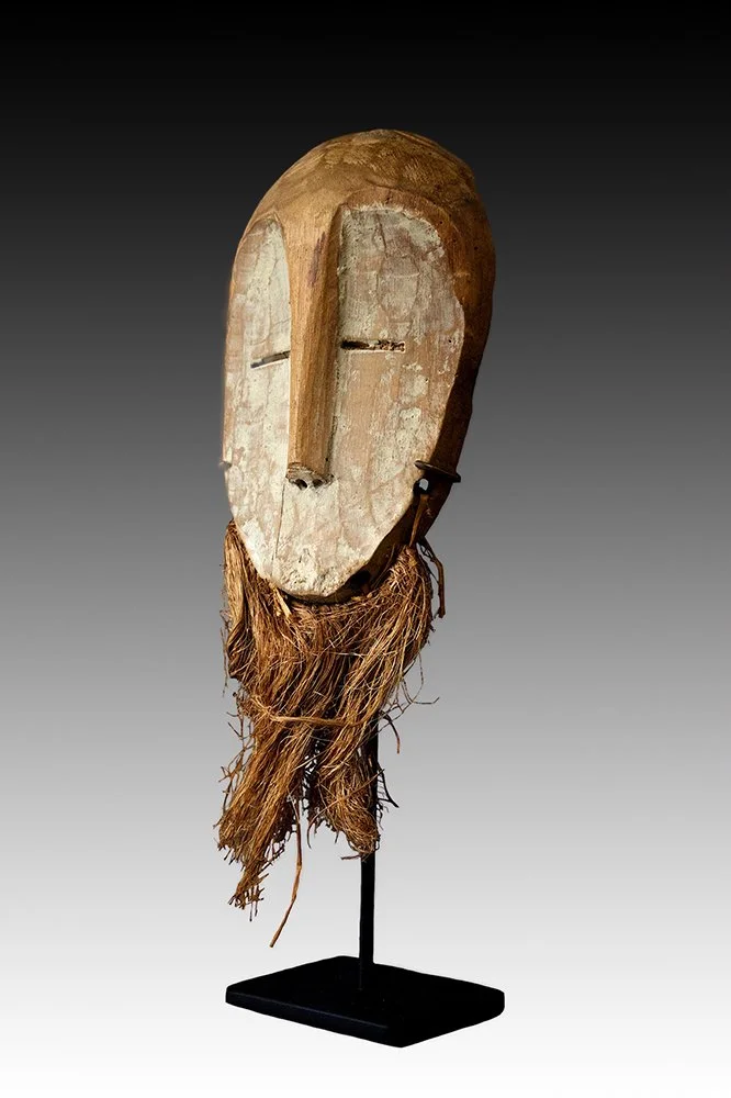 Small lega mask has fiber attached to chin.  www.gallerytribalart.com