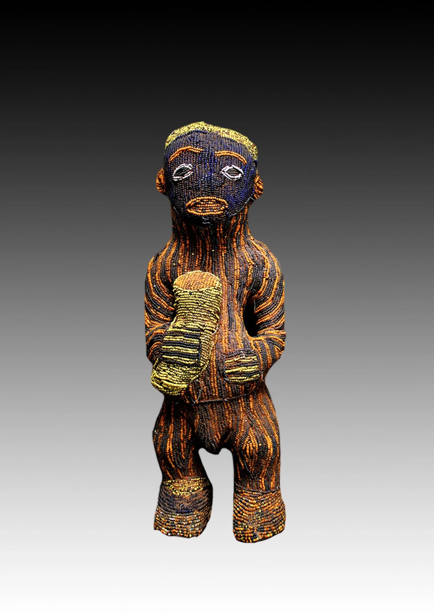 Bamun figure, carved of wood covered with native cloth and is stitched with dark blue, black, orange and yellow glass trade beads.  www.gallerytribalart.com