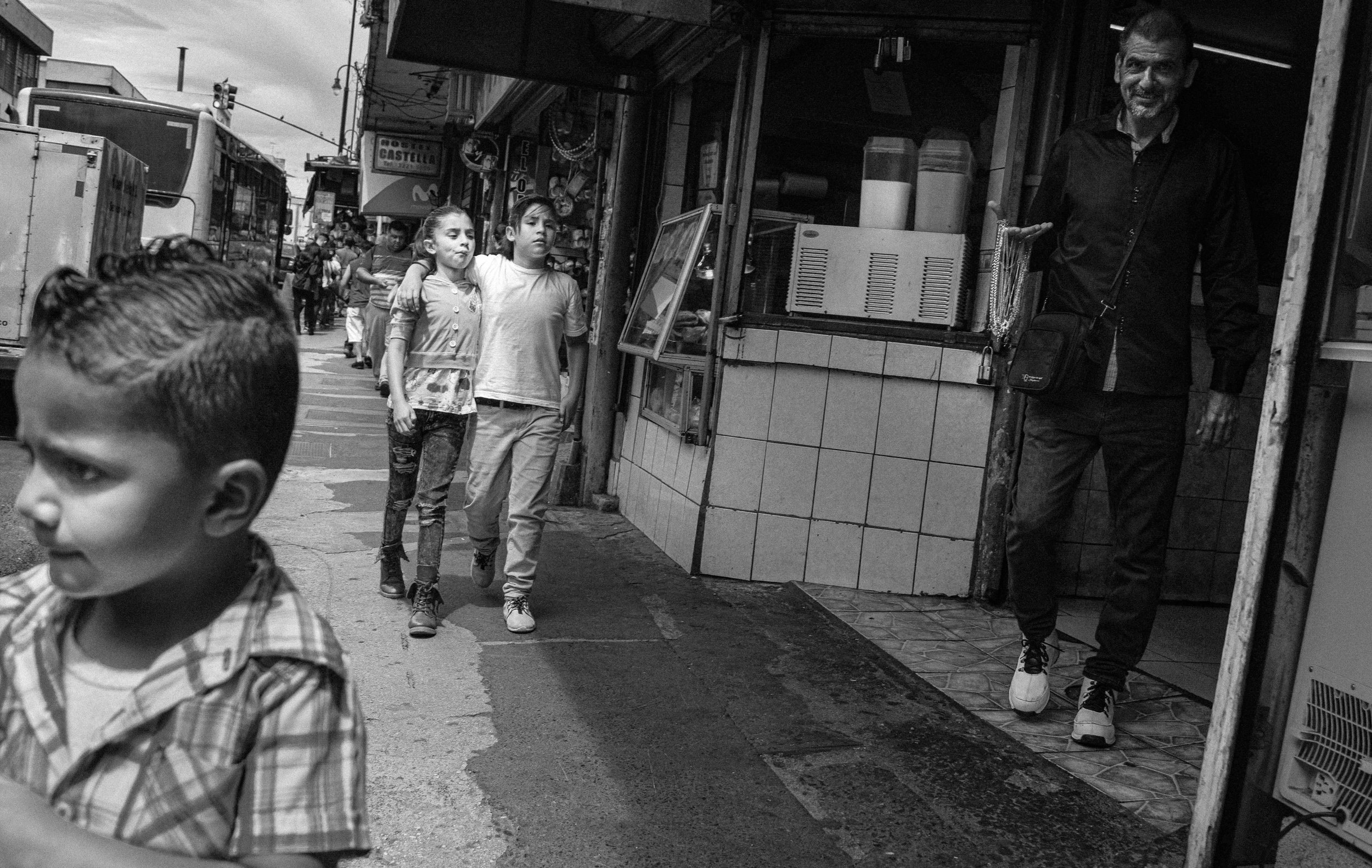 Two friends walking side by side down the street.