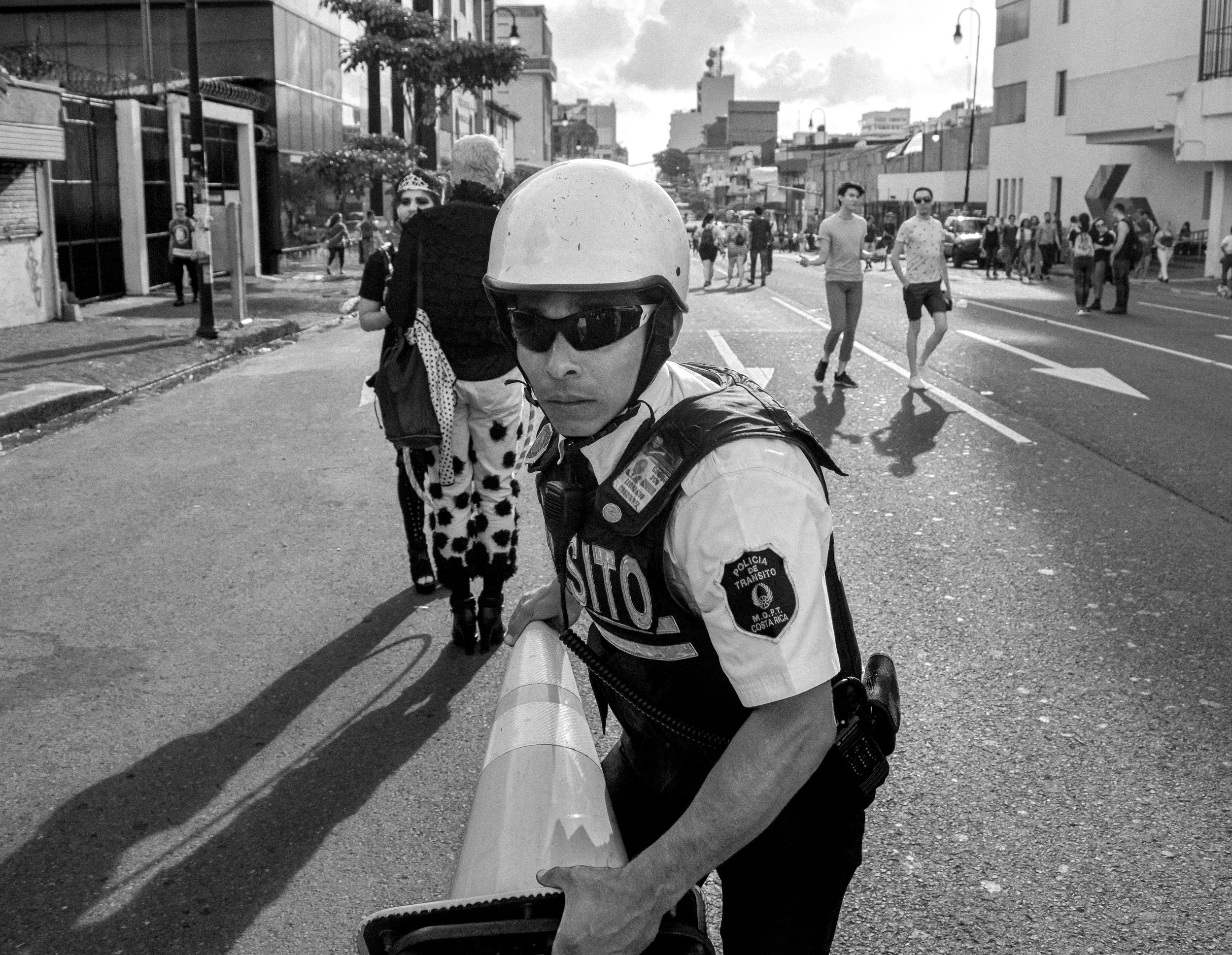 A police man cleans the street after the pride parade.