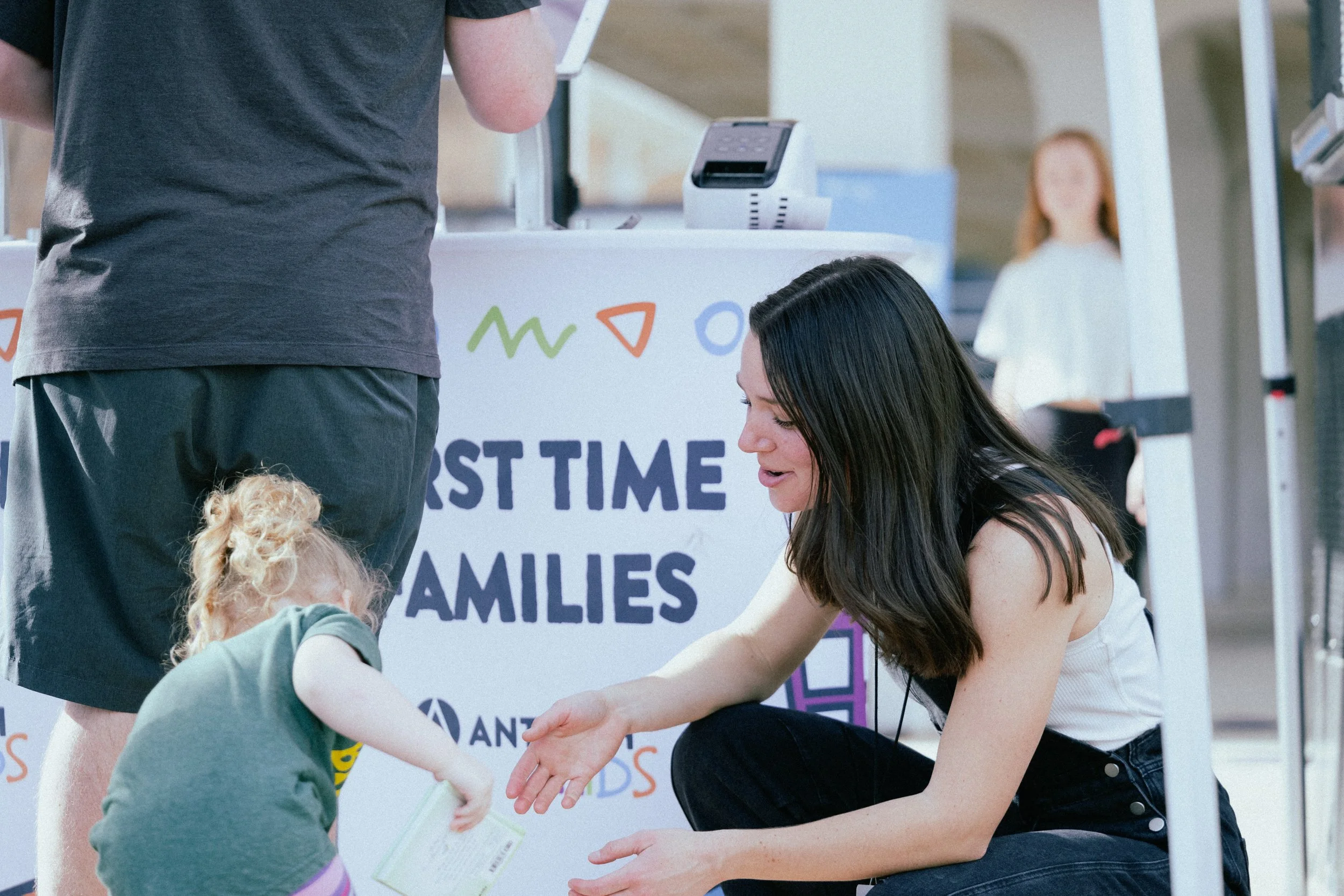 Children playing basketball outdoors near a food truck, with one child about to shoot a ball.