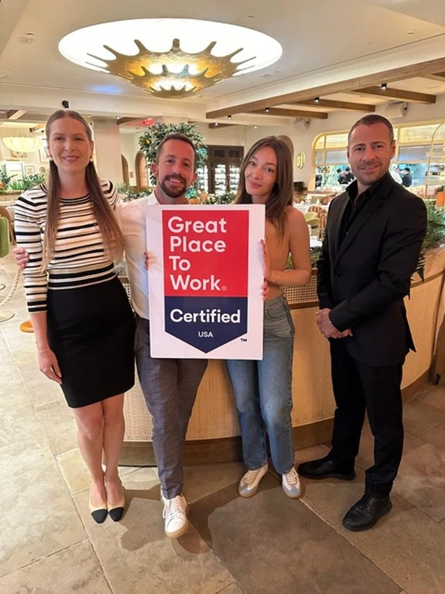 Riviera Dining Group employees smiling as they receive the certification for being a "Great Place to Work".