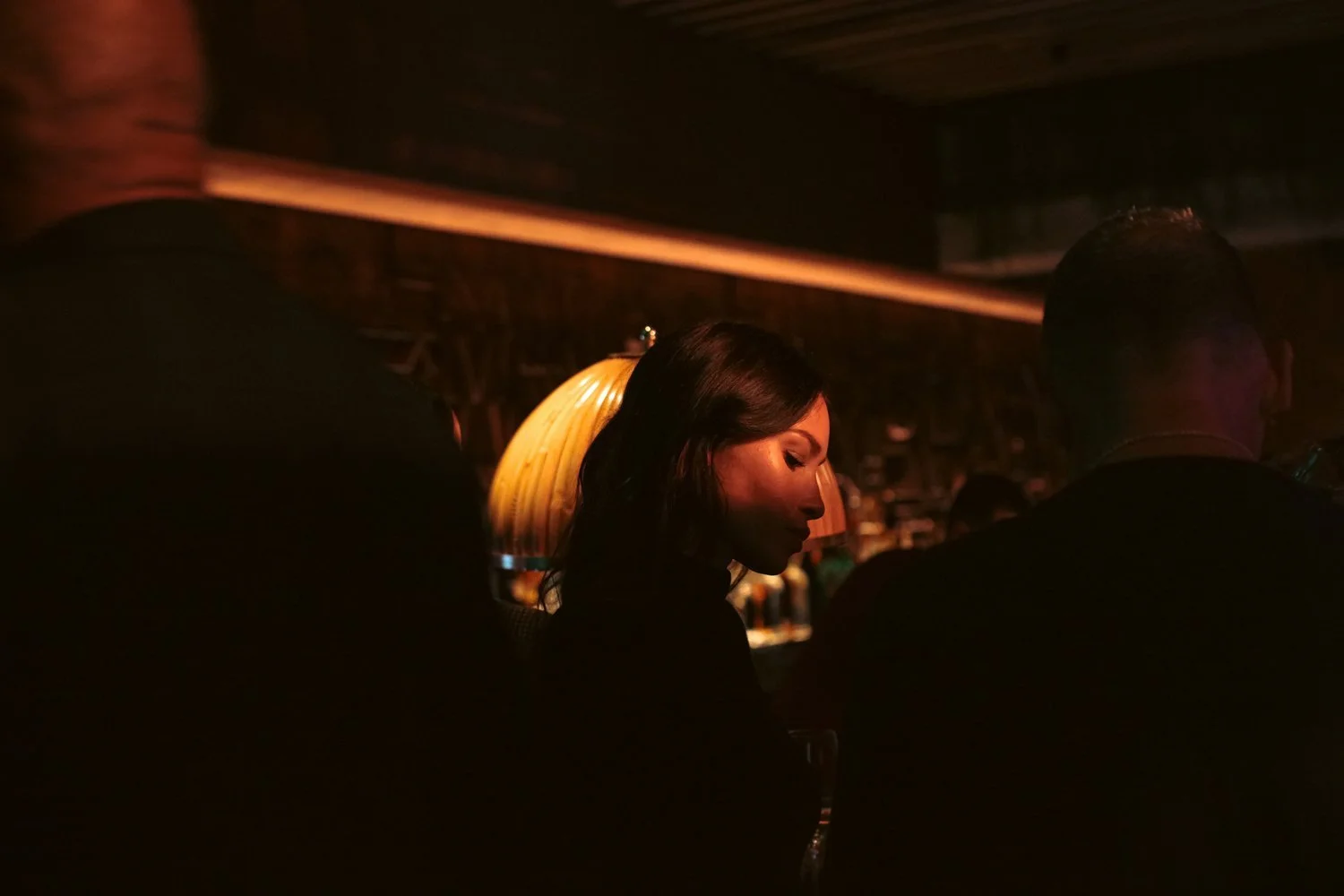 A photo focused on a woman at a private event in MILA Miami, with the lights dimmed.