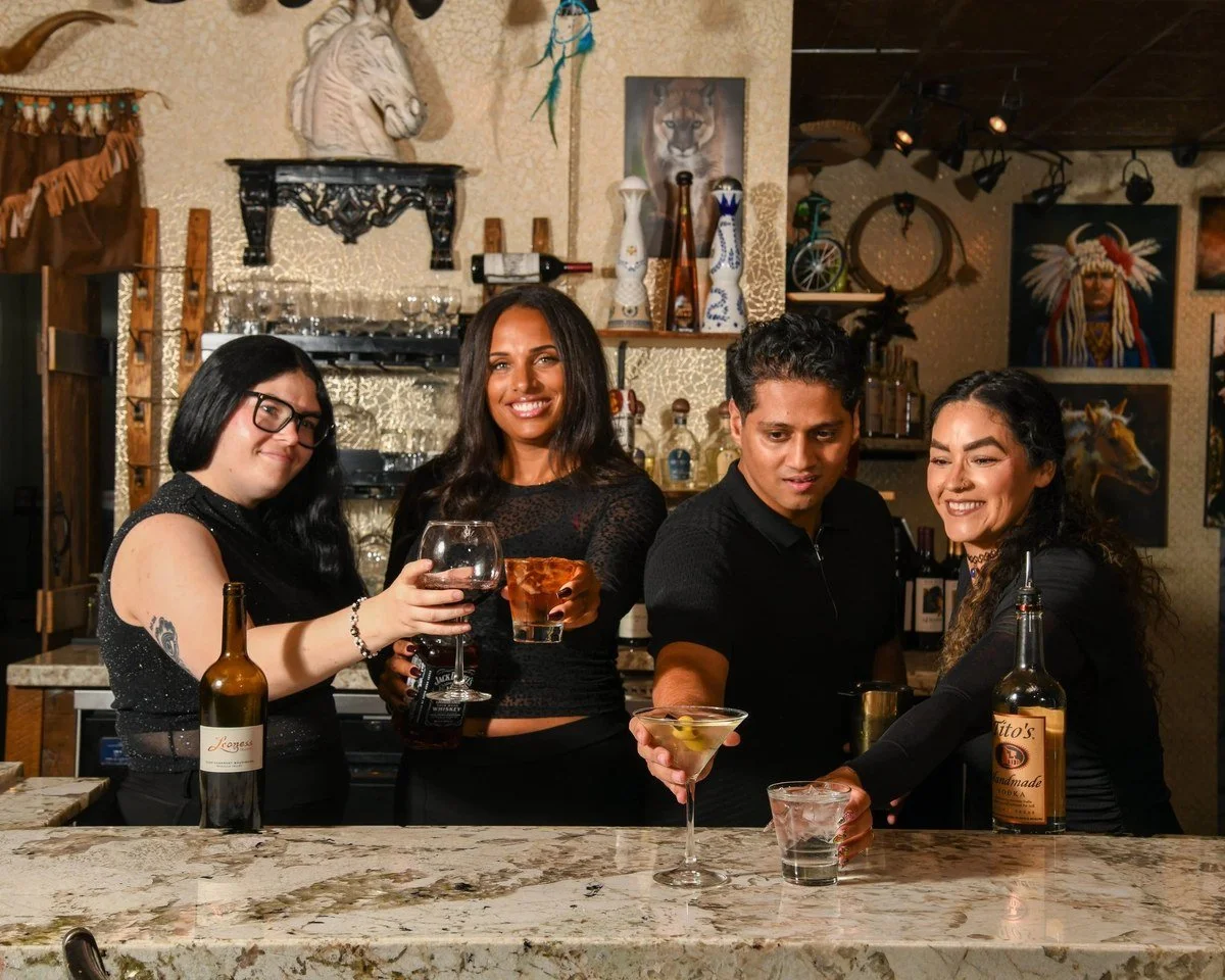 Bar team toasting cocktails at the bar