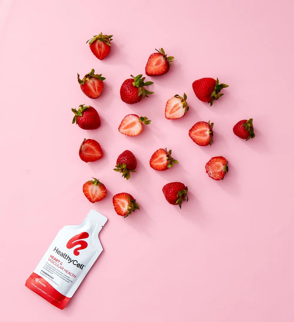 Healthy Cell packet with strawberries on pink, supplement photography