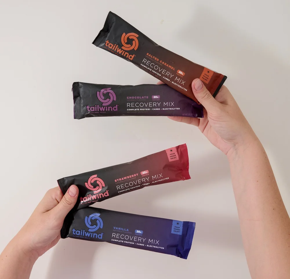 Hands holding three drink mix sticks against white