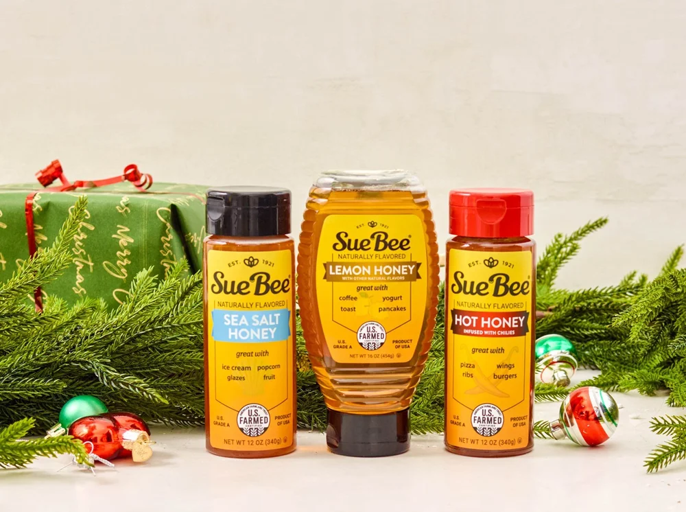 Honey trio in front of wrapped gifts and ornaments