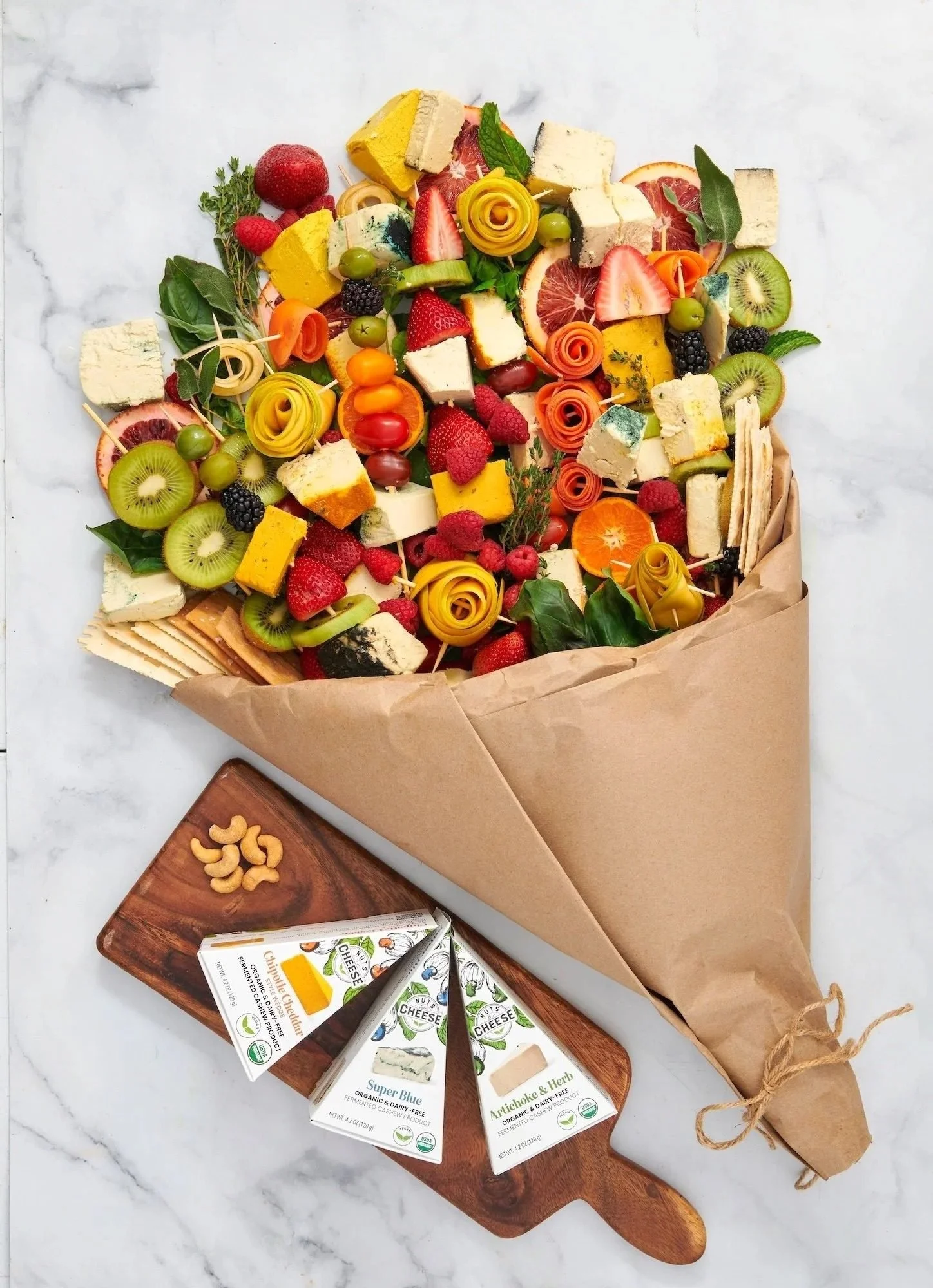 Fruit and cheese bouquet wrapped in paper with cheese packages, CPG entertaining photography