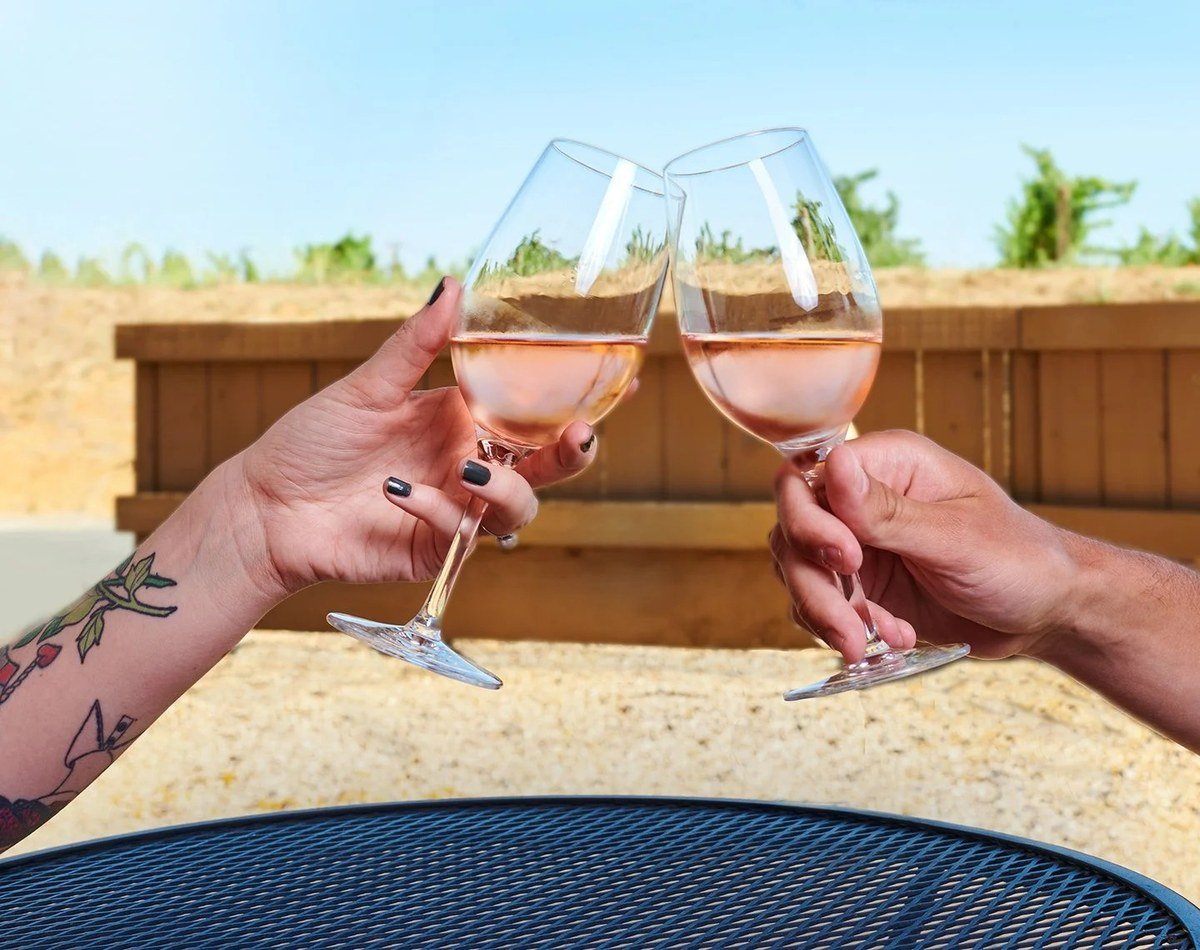 Two hands toasting glasses of rosé wine