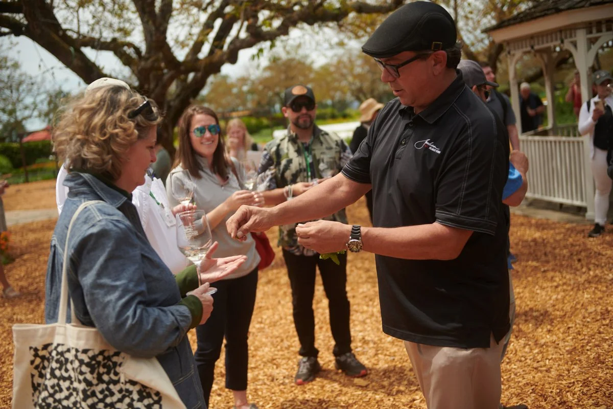 Guide handing out tastes to guests in the garden
