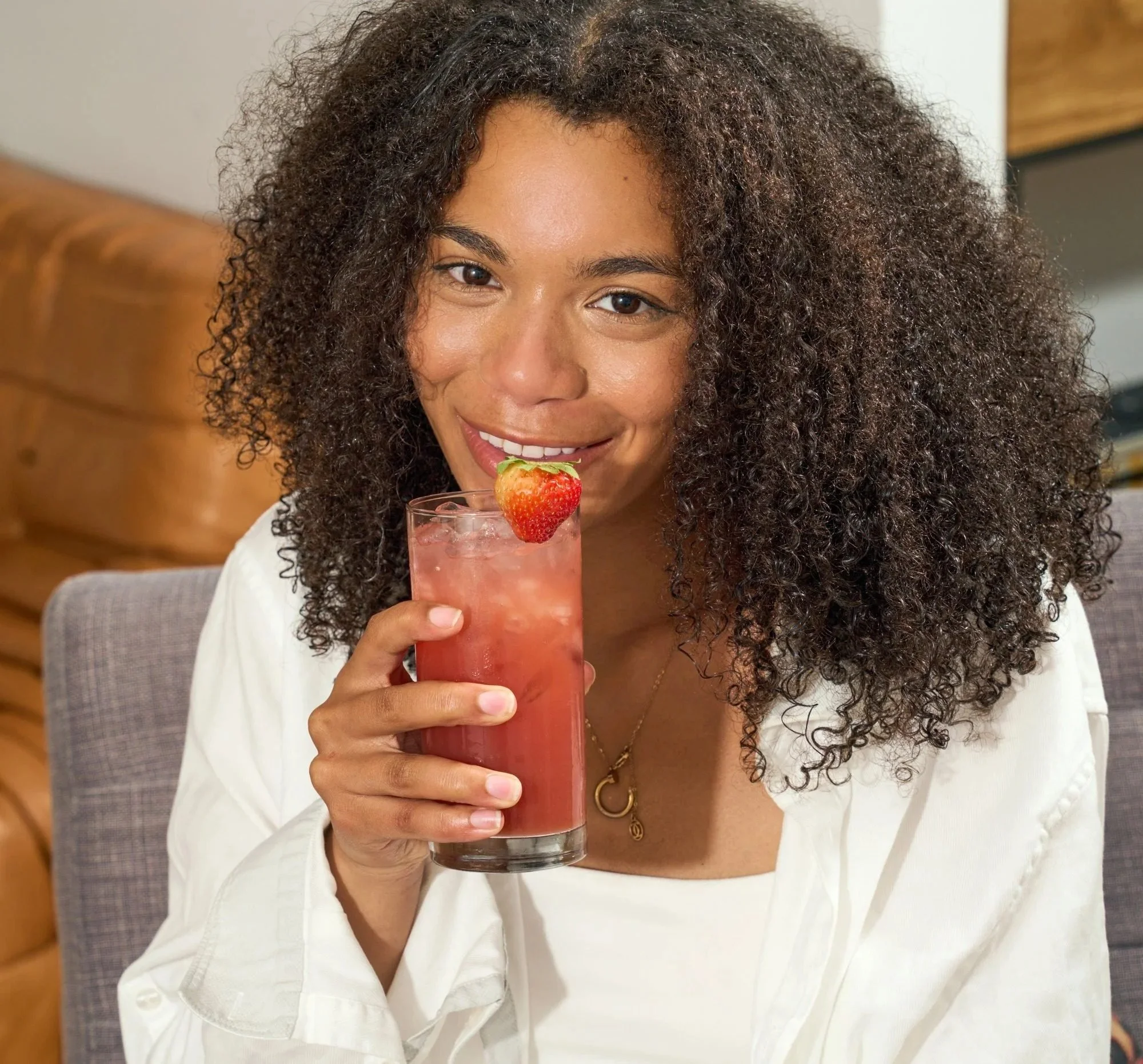 Woman sipping a strawberry drink, beverage lifestyle photography