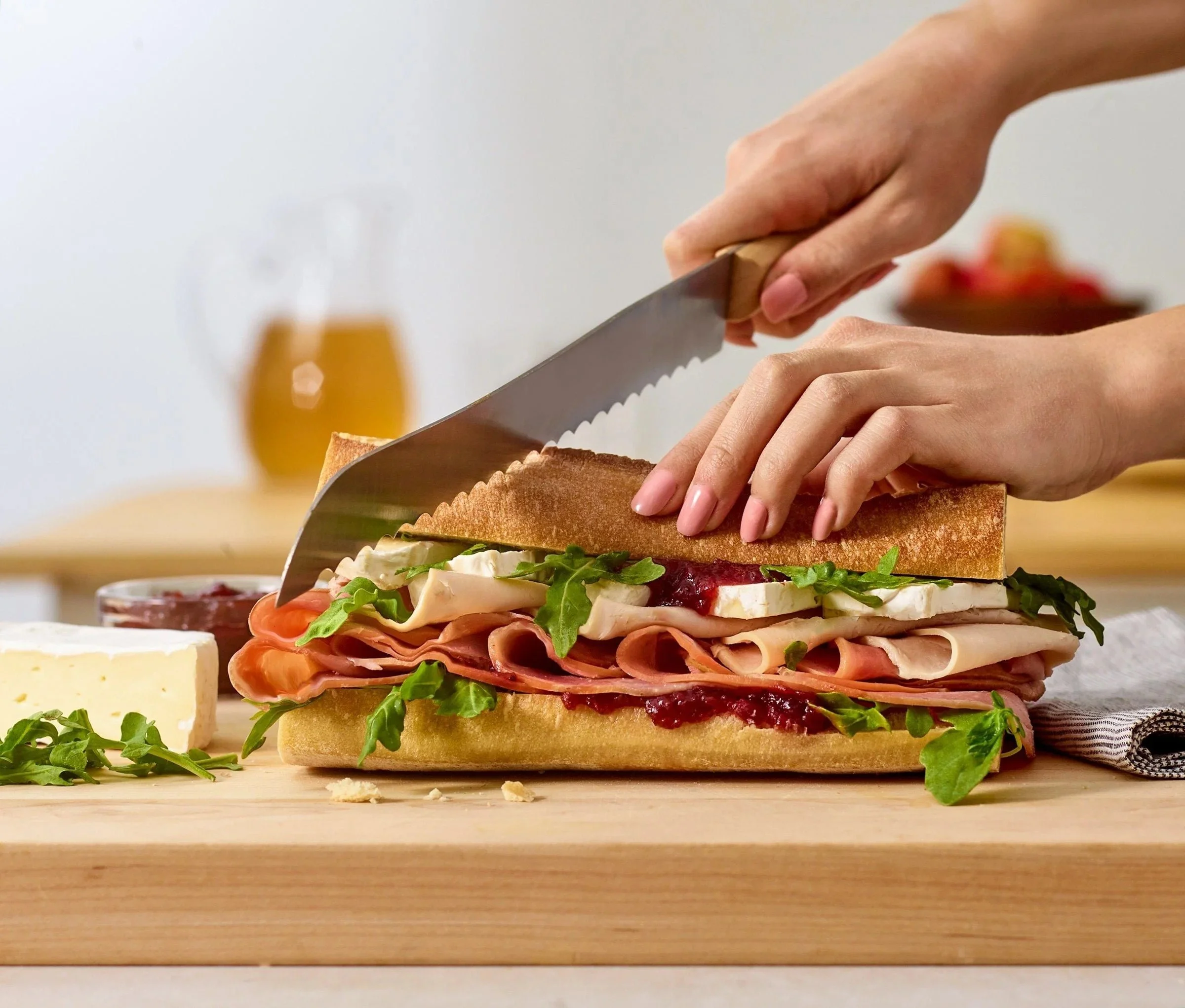 Food styling: slicing a deli sub sandwich on a cutting board