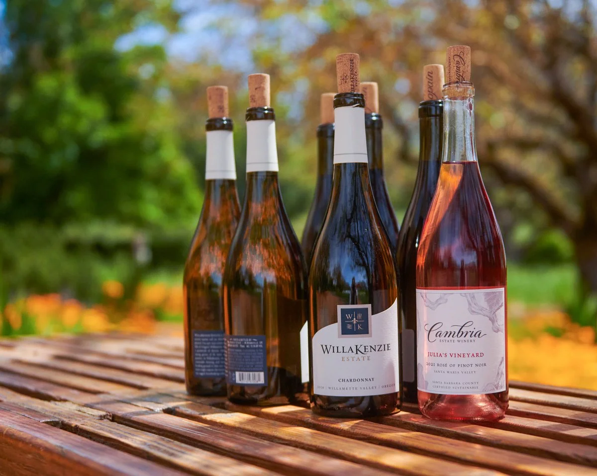 Lineup of wine bottles on a wooden garden table