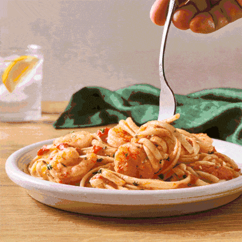 Stop motion GIF of a fork twirling shrimp scampi pasta. Animated pasta content for social and web.